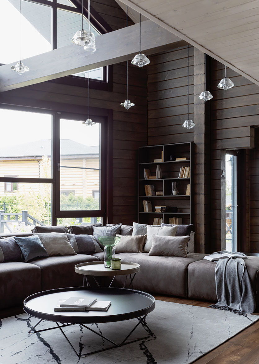Дизайн інтер'єру дерев'яного будинку з бруса: камін, дерев'яні меблі та скандинавський стиль.