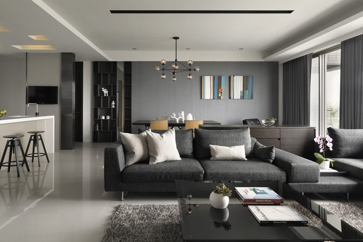 Сучасна вітальня в сіро-білих тонах з диваном та декоративними подушками.