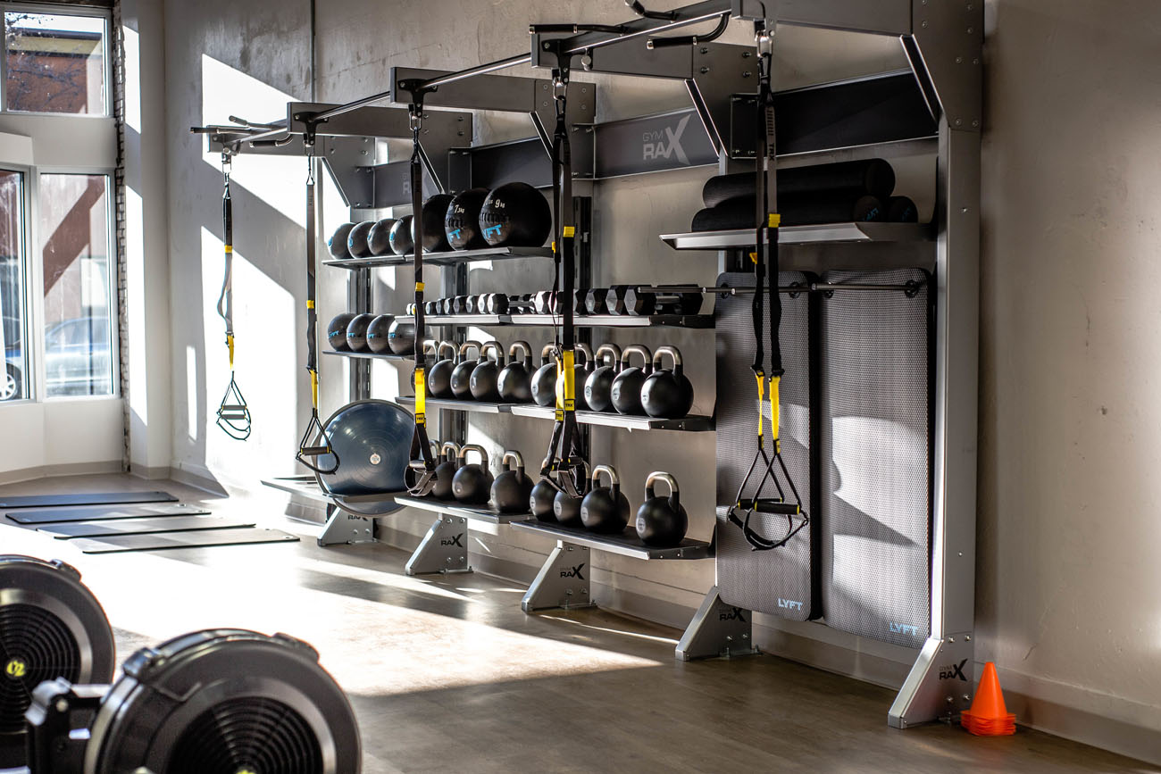 Сучасний домашній спортзал з великим екраном для зручного перегляду онлайн-тренувань вдома.