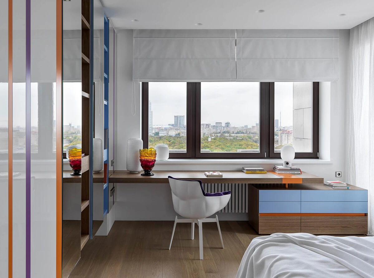 Робочий простір біля вікна з регульованим освітленням та жалюзі для комфортної роботи.