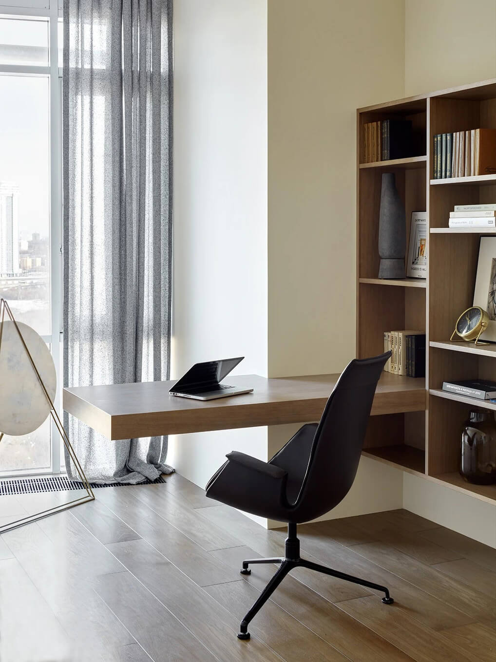 Функціональне робоче місце біля вікна з достатньою кількістю місця для зберігання речей.