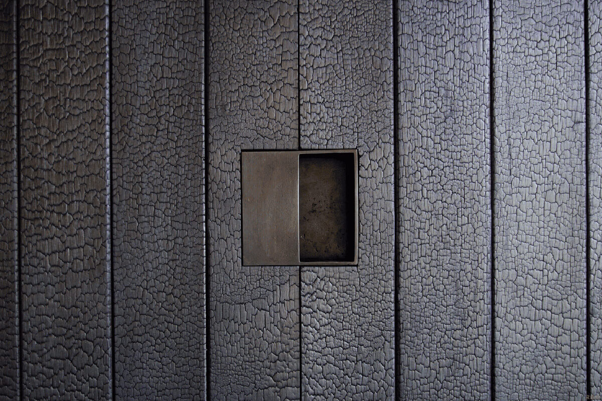 Тепло обпаленої деревини Сучасний інтер'єр з обпаленою деревиною: текстурована стіна додає тепла та мінімалізму.