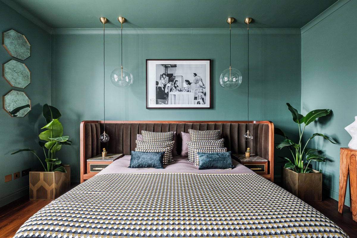 Інтер'єр спальні в зелених тонах з великим вікном і природним освітленням.