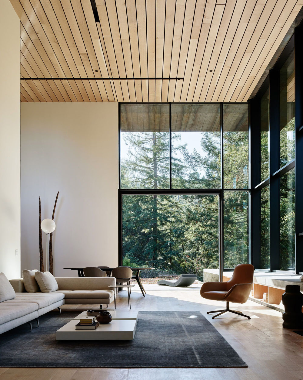 Затишний будинок з каміном і панорамними вікнами з видом на сад.