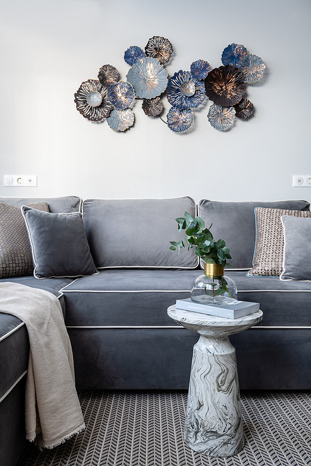 Білий кавовий столик з мармуровим малюнком для вітальні з акцентною стіною.