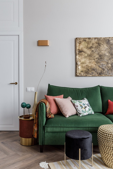 Невеликий журнальний столик-пуф у вітальні з диваном та декоративними подушками.