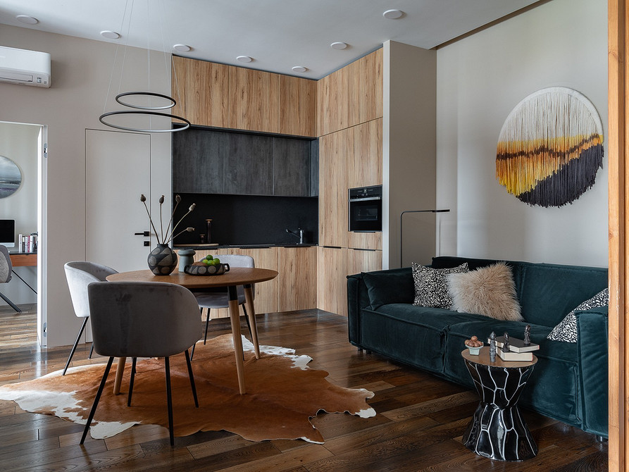 Скляний кавовий столик з мармуровим ефектом у світлій вітальні з рослинами.