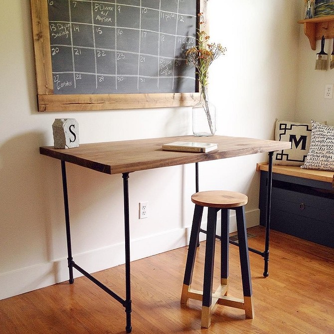 Стіл у стилі лофт Дизайнерський стіл з металевими ніжками з водопровідних труб в інтер'єрі лофт.