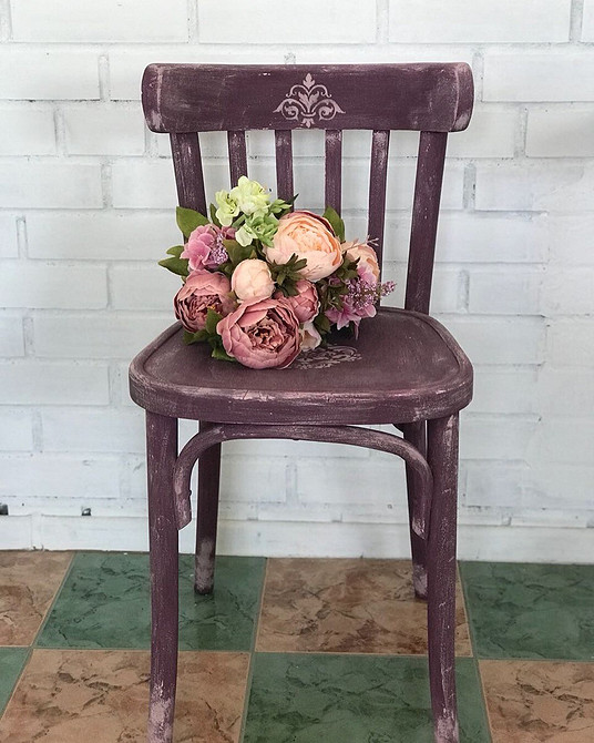 Фарбування старого дерев'яного стільця в яскраві кольори для оновлення дизайну кімнати.