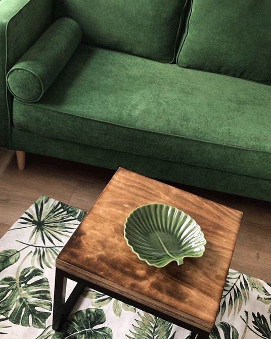 Елегантний круглий журнальний столик зі скляною стільницею в інтер'єрі вітальні.