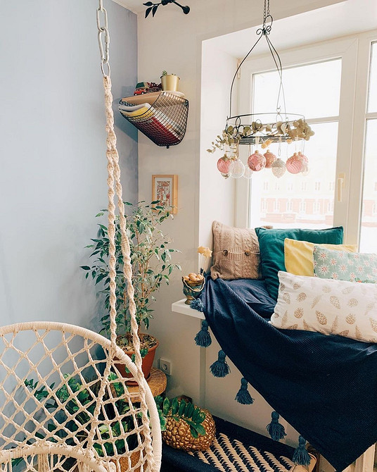 Диван на підвіконні з великою кількістю подушок для максимального комфорту та відпочинку.