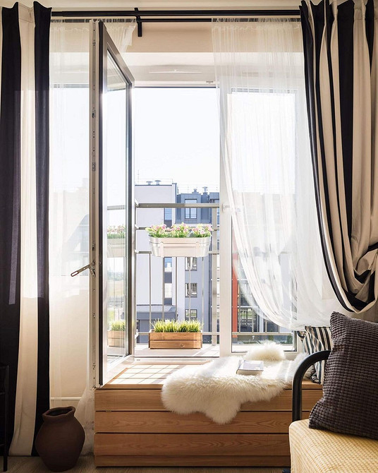 Невеликий диванчик на широкому підвіконні, ефективне використання простору в невеликій кімнаті.