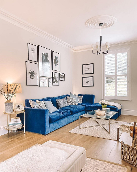 Яскравий жовтий диван у вітальні з кольоровими подушками та килимом.