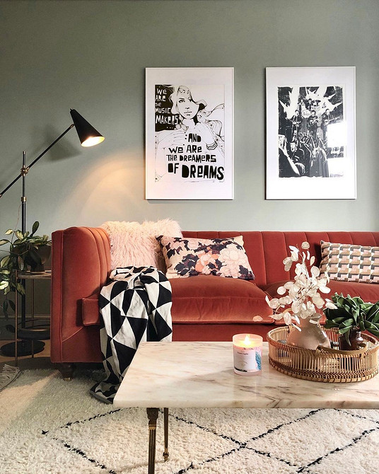 Кольоровий диван як основа інтер'єру вітальні з рослинами та декоративними елементами.