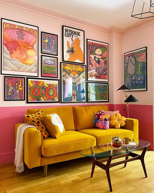 Яскравий диван у вітальні з кольоровими акцентами, журнальним столиком та лампами.