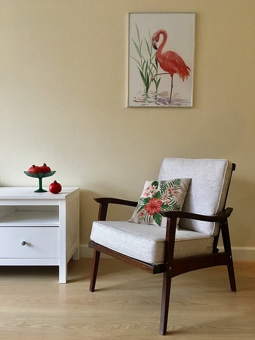 Натуральні матеріали в меблевому дизайні 2024: дерев'яний стіл ручної роботи та стільці з ротангу.