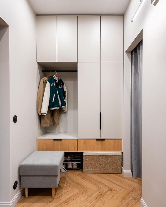 Дизайн спальні з білою шафою та кольоровими шторами, які підкреслюють стиль кімнати.