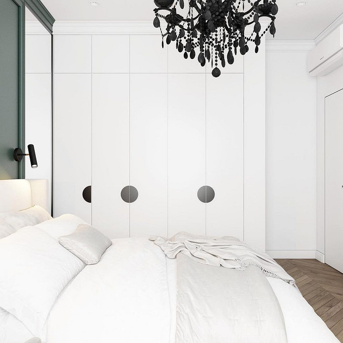 Дизайн спальні з білими меблями, доповнений картинами на стінах у теплих тонах