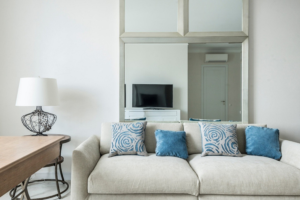 Еклектичний диван Білий диван в еклектичному інтер'єрі з поєднанням різних стилів та текстур.