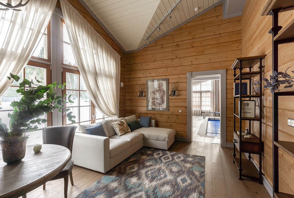 Бохо-натхнення Інтер'єр в стилі бохо з білим диваном, картинами на стінах та яскравими акцентами.