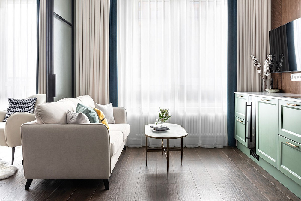 Еко-стиль Екологічна вітальня з білим диваном, зеленими рослинами та дерев'яними меблями в еко-стилі.