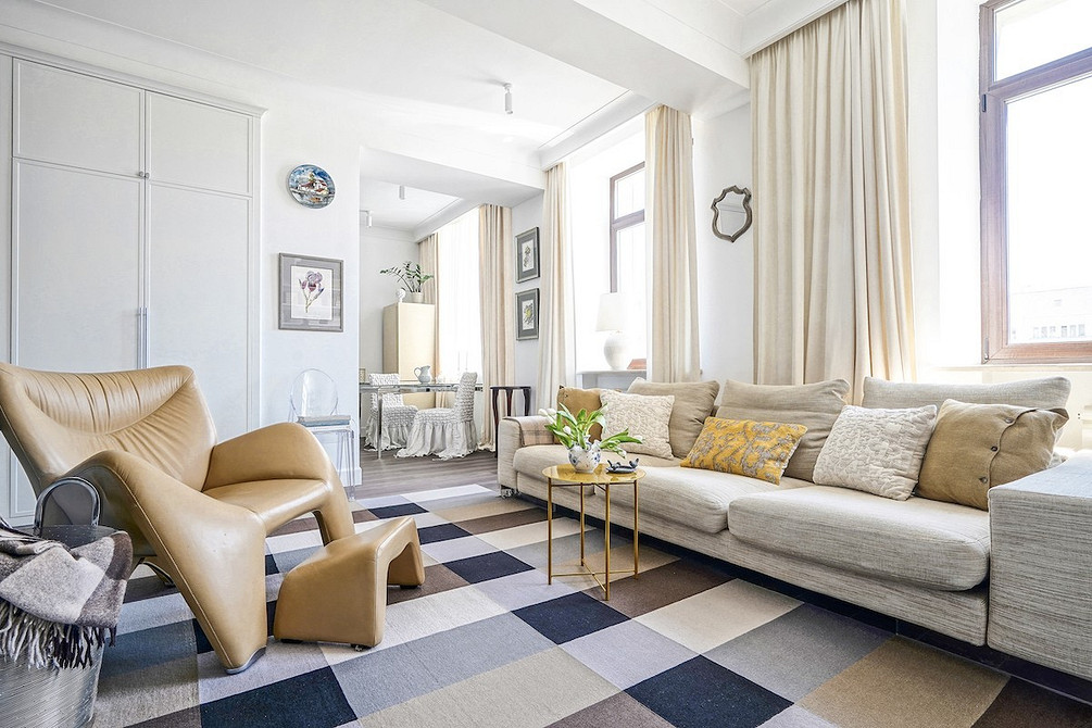 Акцент на дивані Сучасний білий диван з кольоровими подушками на фоні акцентної стіни в інтер'єрі.