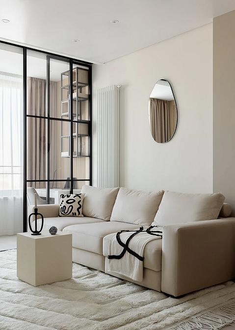 Бежевий диван, яскраві картини та кольорові подушки у сучасній вітальні.