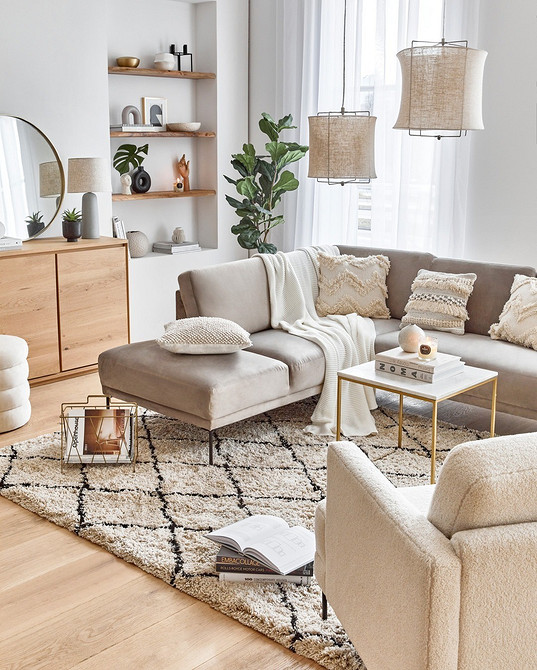 Бежевий диван в скандинавському стилі з дерев'яними ніжками та текстильною оббивкою.