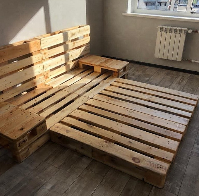 Недорогий диван з палет з подушками різних розмірів для маленької квартири.
