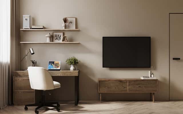 Елементи декору в трикімнатній квартирі: подушки, картини та рослини у вітальні.