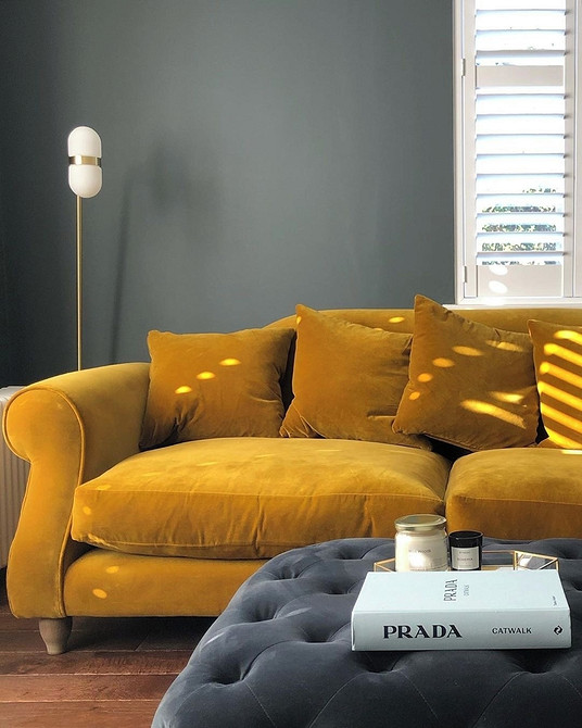 Яскравий акцент у кімнаті Яскраво-жовтий сучасний диван як ключовий елемент у вітальні в скандинавському стилі.