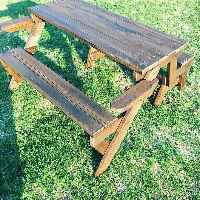 Пошкоджені старі садові меблі очікують відновлення: старі дерев’яні стільці на газоні.