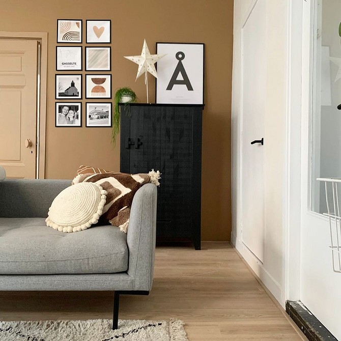 Стильний сірий диван ідеально підібраний до світло-сірих стін у вітальні.