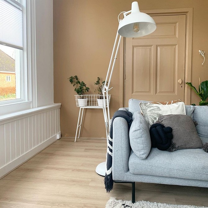 Дизайн вітальні з яскравим жовтим диваном, що контрастує зі стінами.