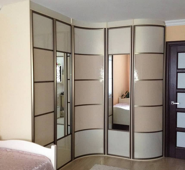 Практичне рішення Світла спальня з кутовою шафою-купе: сучасний дизайн та практичне рішення для зберігання.