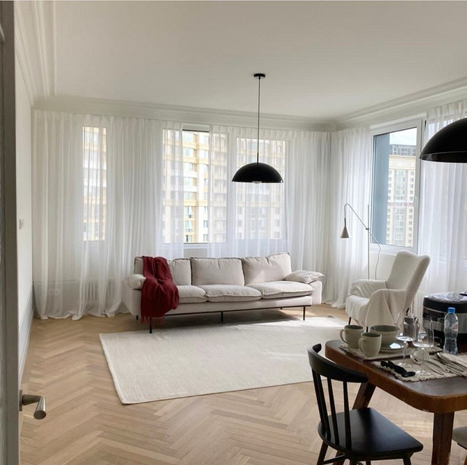 Диван на тонких ніжках з подушками в стилі мінімалізм для легкої кімнати.