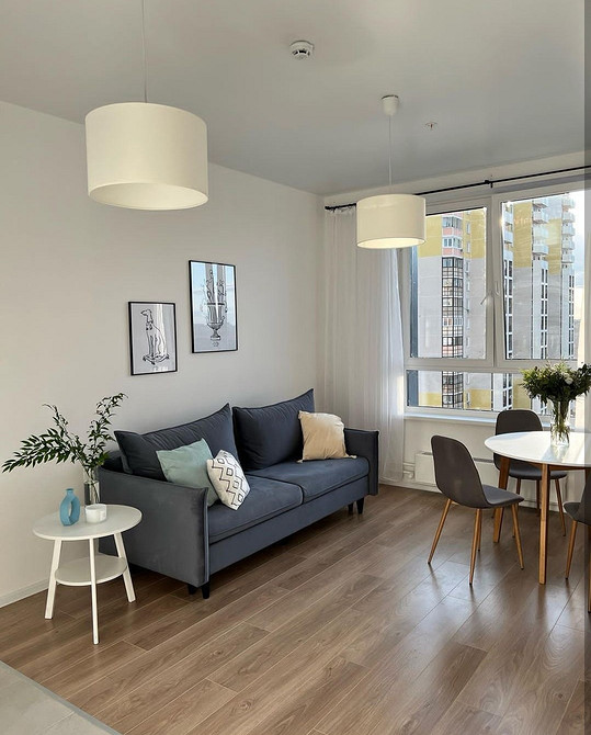 Стильний диван на ніжках у світлому інтер'єрі вітальні, сучасний стиль 2026.