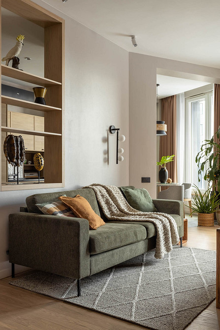 Сучасний диван на ніжках у вітальні з килимом та елегантним декором, 2026.