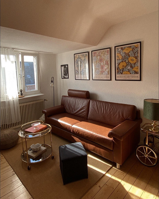 Розкішний шкіряний диван світлого відтінку в сучасному інтер'єрі з журнальним столиком.