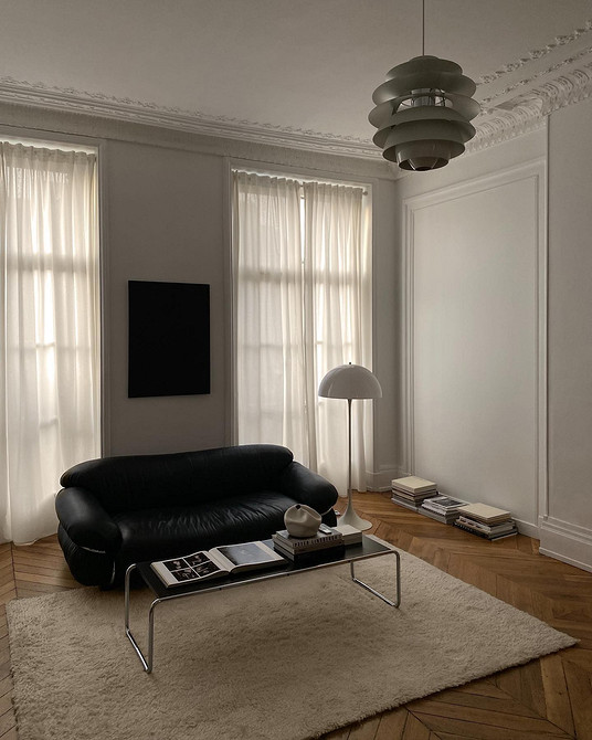 Шкіряний диван зеленого кольору в вітальні з рослинами, еко-дизайн інтер'єру.