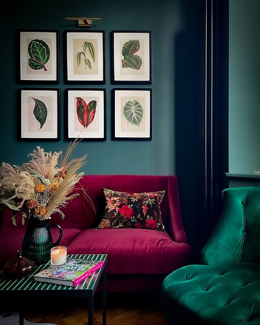 Червоний диван в інтер'єрі з різнобарвним текстилем: еклектичний та сміливий стиль вітальні.