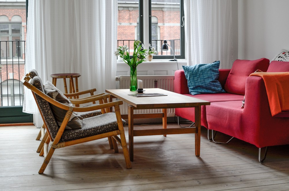 Інтер'єр з червоним диваном, синіми акцентами, гармонійне поєднання кольорів у дизайні кімнати.