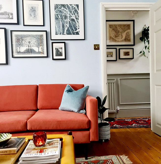 Інтер'єр вітальні: поєднання червоного дивана, сірих стін та дерев'яного столика.
