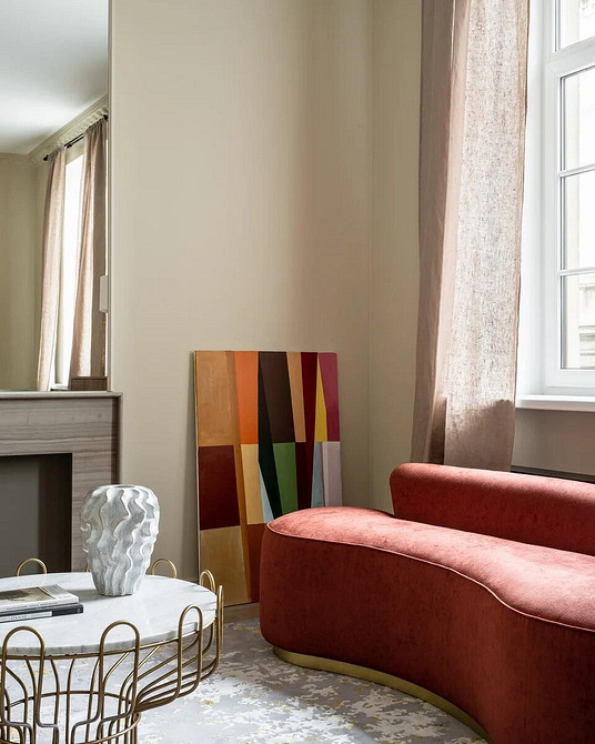 Комфортний інтер'єр з червоним диваном і бежевим килимом: стиль та затишок.