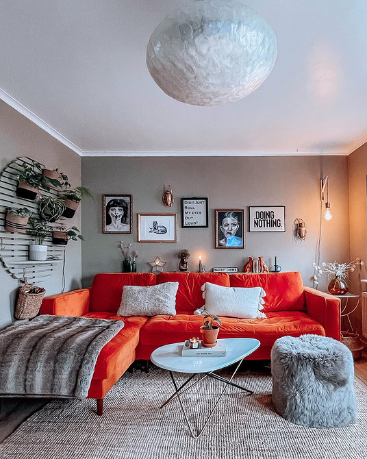 Поєднання кольорів у вітальні: червоний диван та інші елементи інтер'єру.