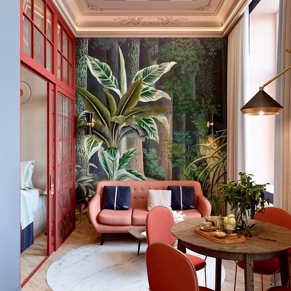 Вітальня з червоним диваном та світлими стінами: відчуття простору та яскравості в кімнаті.