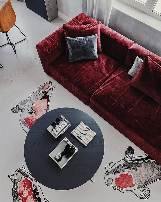 Кутовий червоний диван та журнальний столик у просторій вітальні