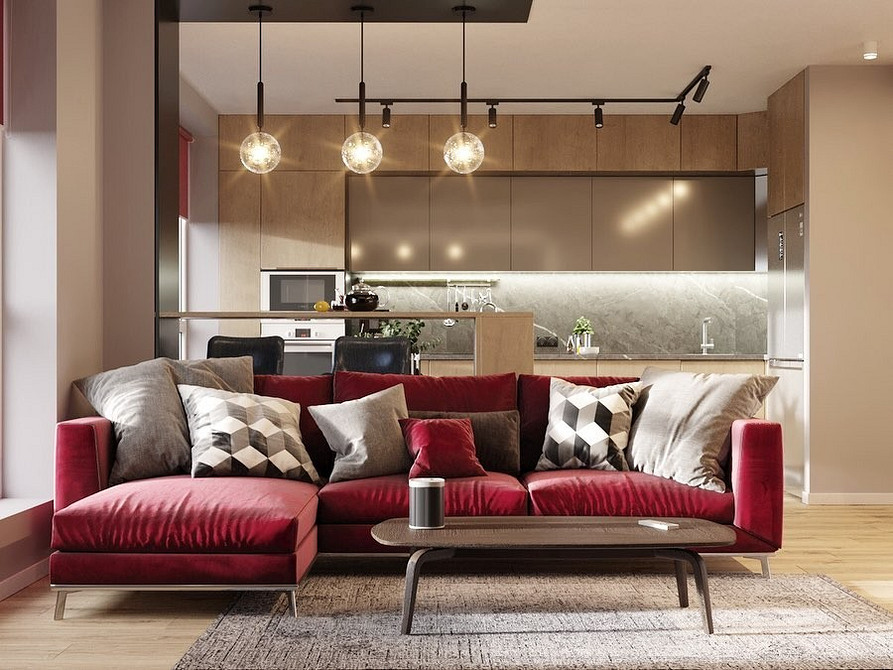 Кімната з червоним диваном та зеленими рослинами, вдале поєднання кольорів в інтер'єрі.