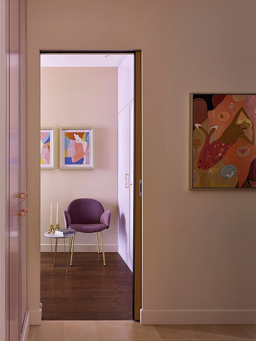 Крісло з дерев'яними підлокітниками та м'якою оббивкою в затишному інтер'єрі вітальні.