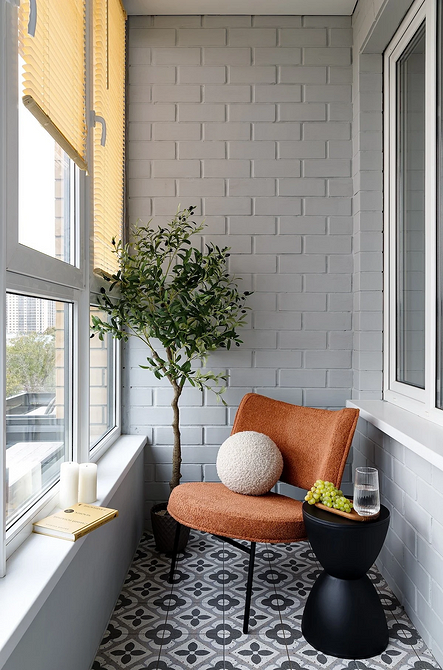 Крісло-гойдалка на балконі з пледом: затишне місце для релаксації з видом на місто.